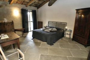 蒙福特达尔巴Le Case della Saracca的卧室配有一张床和一张桌子