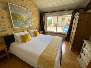 Saint-MathieuLa Porcherie的一间卧室配有一张带黄色枕头的大床