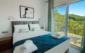 帕尔加Natura Luxury Suites Parga的一间卧室设有一张床和一个大窗户