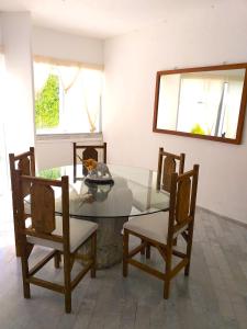 坎昆casa HIKURI的一间设有玻璃桌和椅子的用餐室