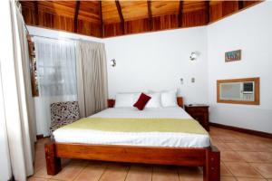 普拉亚埃尔莫萨Acacia Playa Hermosa的一间卧室配有一张红色枕头的床