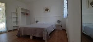 奥特朗托Molto Benissimo的一间铺有木地板的白色卧室,配有一张床