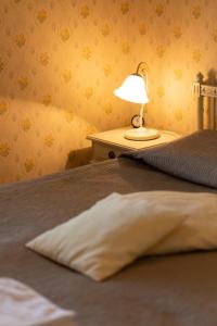 萨翁林纳罗曼欧琪拉住宿加早餐酒店的一张带枕头的床和一张桌子上的台灯