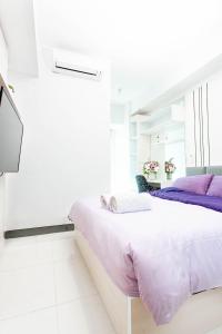 LontarNEW 2Br Apartment in Benson Connected to Pakuwon Mall Surabaya Barat的白色客房的两张床,配有紫色床单