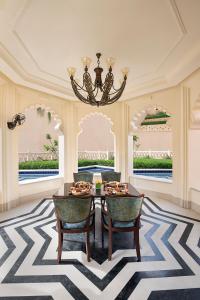 乌代浦Aurika, Udaipur - Luxury by Lemon Tree Hotels的一间带桌椅和吊灯的用餐室