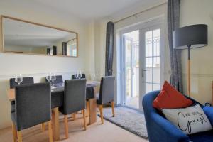 莱姆里吉斯Anning's View的一间带桌子和蓝色沙发的用餐室