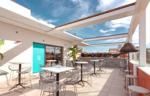 马拉加Apartamentos Málaga Premium - Calle Granada的一个带桌椅的庭院和一间酒吧