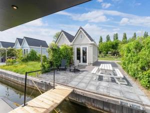 斯塔福伦Brand new Boathouse on the water in Stavoren with a garden的白色的房子,旁边是水体