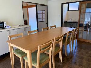 Noroshi九右衛門ゲストハウス(kuemon guesthouse)的厨房里配有一张木桌和椅子