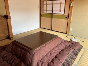 Noroshi九右衛門ゲストハウス(kuemon guesthouse)的一张位于房间地板上的床铺