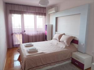 布尔加斯Luxury Panoramic Seaside Apartment的一间卧室设有一张大床和一个大窗户