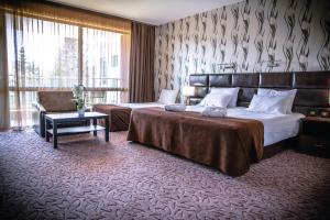 韦林格勒Zdravets SPA Hotel的酒店客房,配有两张床和椅子