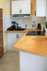 SīkragsCozy Cottage的厨房配有白色橱柜和木制台面