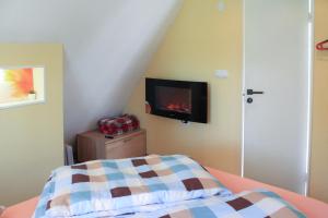 SīkragsCozy Cottage的卧室配有一张床,墙上配有电视。