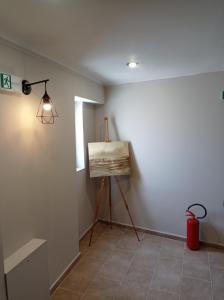 比雷埃夫斯Elaėa Boutique Apartments的灯火通明的房间的三脚架上的绘画