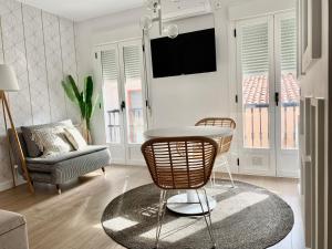 普拉森西亚Apartamentos Succo的客厅配有桌子和椅子