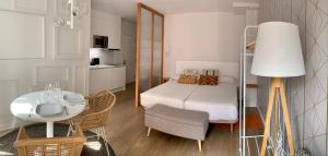 普拉森西亚Apartamentos Succo的小房间设有床、桌子和椅子