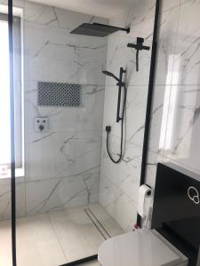 萨尔格米纳Studio calme-équipements haut de gamme的一间设有白色大理石墙壁和淋浴的浴室