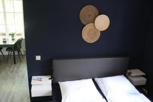 StegerenErve Praestinck的一间卧室设有黑色墙壁、一张床和两顶帽子