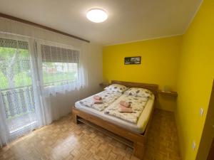 科巴里德Apartment Konavec的一间卧室设有一张黄色墙壁和窗户的床