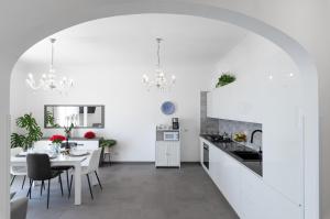 普莱伊亚诺Casa Clara的厨房以及带白色墙壁和桌子的用餐室