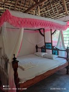 瓦塔穆Mida Creek Eco Camp的一间卧室配有一张带天蓬的床