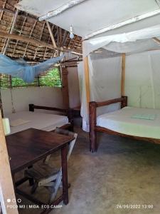 瓦塔穆Mida Creek Eco Camp的一间设有两张床和一张桌子的房间