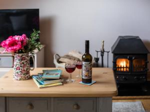 Little WitcombeAmber Cottage的一张桌子,上面放着一瓶葡萄酒和两杯酒