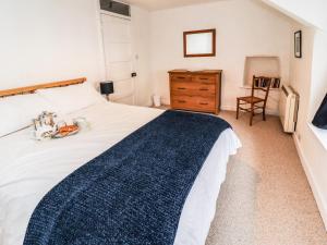 欧克汉普敦Lavender Cottage的卧室配有白色大床和木制梳妆台