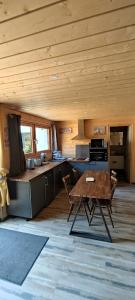 普雷芒翁Cahute de montagne pour profiter du Haut Jura的小屋内的厨房配有桌椅