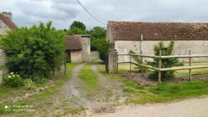 Pertheville-NersLa Maison de Ners的一座带围栏和土路的老农场
