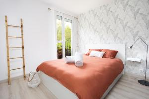 默伦LeCosyMelunais : Parking gratuit + Balcon aménagé的一间卧室配有一张带橙色毯子的床