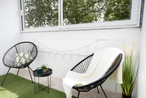 默伦LeCosyMelunais : Parking gratuit + Balcon aménagé的庭院配有两把椅子和一张桌子