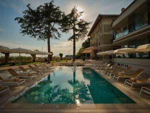 诺维格勒伊斯特拉Palazzo Rainis Hotel & Spa - Small Luxury Hotel - Adults Only的一座带躺椅的游泳池和一座建筑