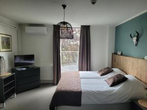 梅赫伦山花旅馆的一间卧室配有一张床、一台电视和一个窗口