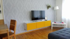 上施陶芬FeWo Panorama270, Oberstaufen/Steibis的客厅设有黄色橱柜和电视机