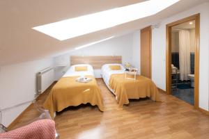 瓜达拉哈拉Apartamento La Merced.的一间卧室配有两张带黄色毯子的床