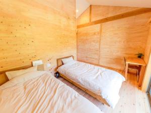 奄美Guest House Amami Long Beach 2 - Vacation STAY 37974v的木墙客房的两张床