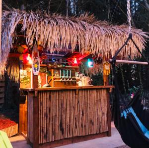 GalstonAirstream Woodland Escape的一间设有稻草屋顶和吊床的酒吧