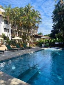 廷博天宝园酒店的一座游泳池,里面摆放着椅子和棕榈树