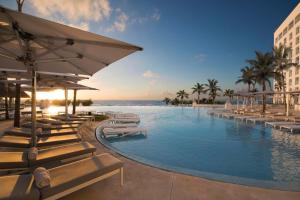 坎昆Le Blanc Spa Resort Cancun Adults Only All-Inclusive的一个带躺椅的度假游泳池以及大海