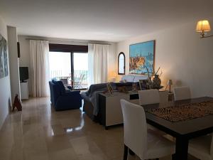 阿尔加德萨Amplio apartamento en Portofino Alcaidesa的带沙发的客厅和用餐室