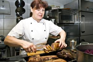 Görisried泽姆赫希酒店的坐在厨房里,在柜台上准备食物的女人