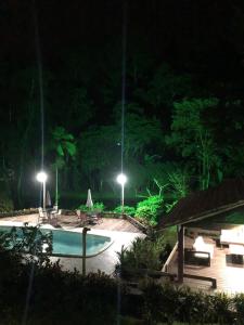安格拉杜斯雷斯Sítio Bagatelle com cachoeira e piscina!的游泳池的夜景