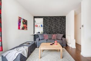 伦敦Bright and stylish apartment in trendy Islington by UnderTheDoormat的客厅配有沙发和桌子