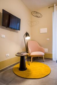 卡利Cielo e Nuvole的客厅配有椅子、桌子和电视