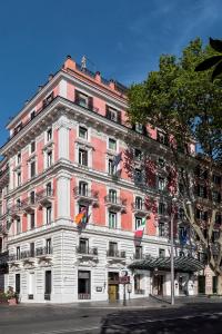 罗马巴廖尼女王饭店 –立鼎世酒店集团的街道上一座粉红色和白色的大建筑