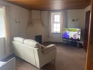 圣比斯Fairladies Barn Guest House的客厅配有白色沙发和平面电视。