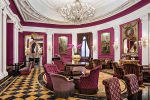 罗马巴廖尼女王饭店 –立鼎世酒店集团的一间设有紫色墙壁和椅子及吊灯的房间