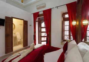 马拉喀什Riad Morocco Sky的一间卧室配有一张带红色窗帘和镜子的床